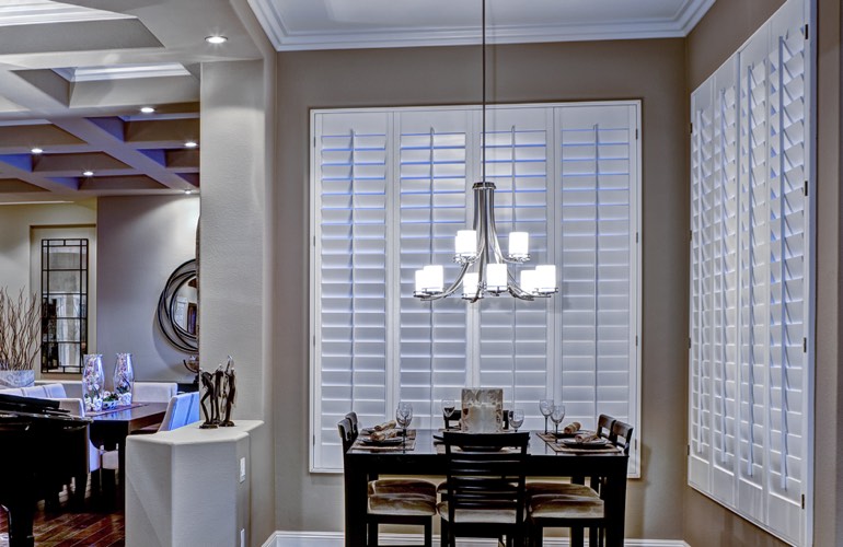 Modern dining room with white plantation shutters on two walls